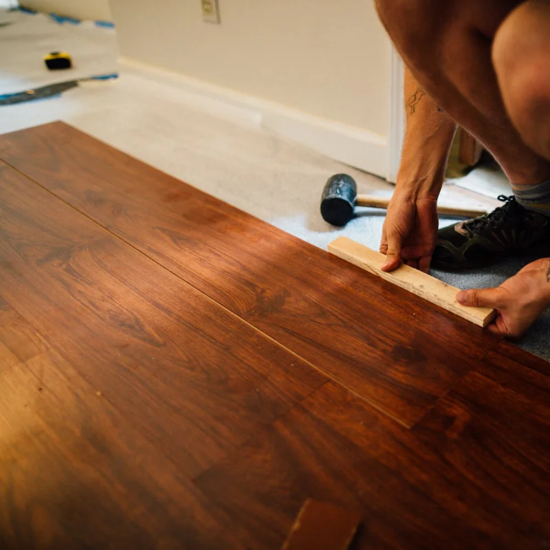 flooring installer combining ceramic and wood flooring in a modern pattern